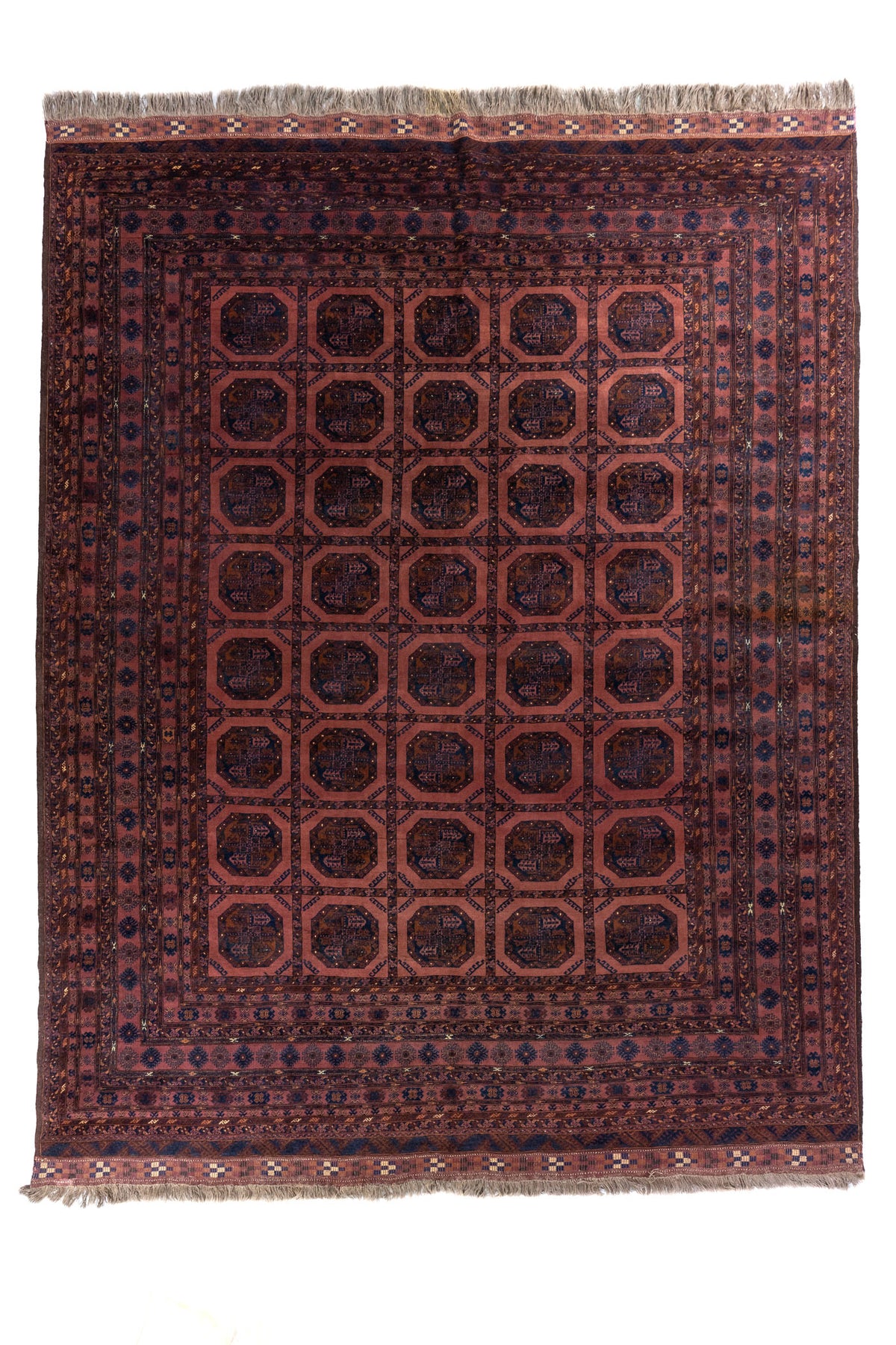 Alfombra oriental en tonos marrón y azul marino con diseño repetitivo de medallones octagonales tradicionales.