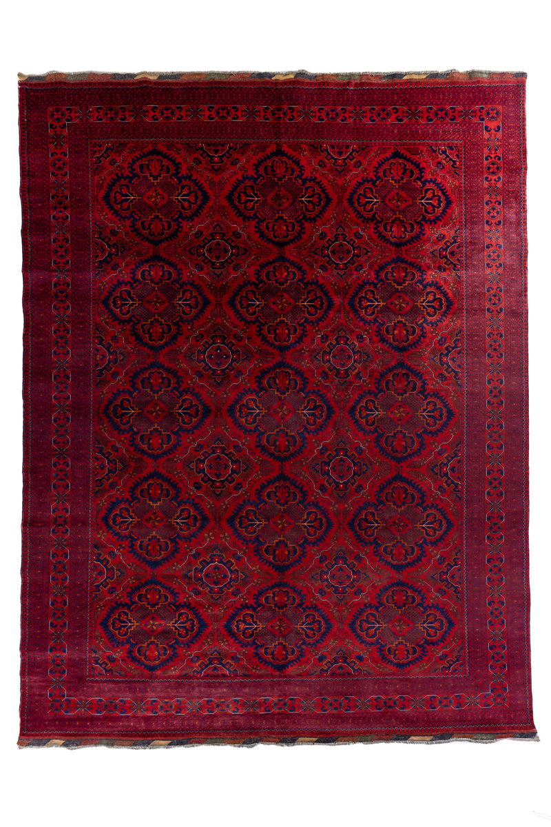 Vista completa de alfombra roja estilo Kazak con patrones geométricos y bordes ornamentados.