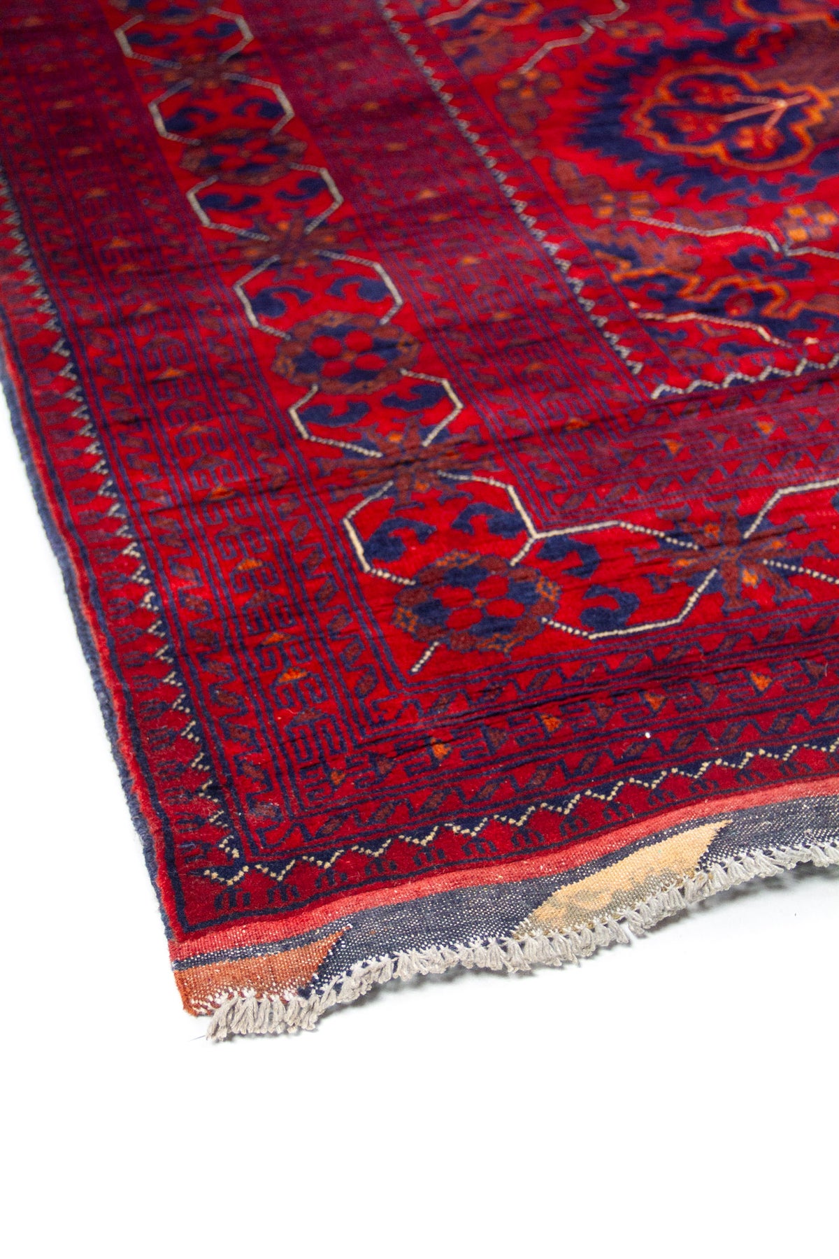 Detalle del diseño central de alfombra roja con medallones simétricos y patrones tribales.