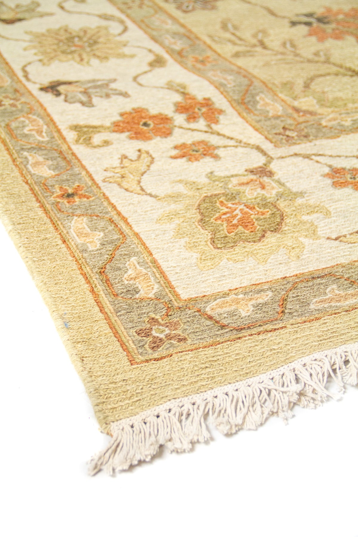 Detalle de borde y flecos en alfombra clásica beige con diseño floral ornamental