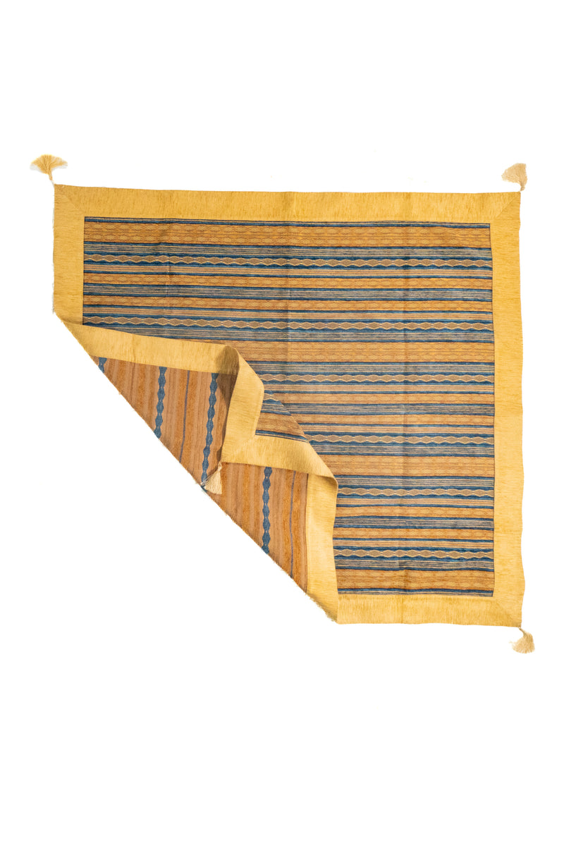 Textil decorativo rectangular amarillo y azul con rayas y esquina doblada
