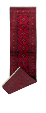 Alfombra roja de pasillo vista completa con una esquina doblada, mostrando el reverso tejido y los flecos beige.