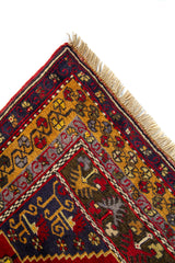 Primer plano de borde de alfombra oriental con flecos claros y patrones geométricos en rojo, azul y dorado
