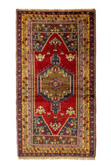 Alfombra oriental rectangular con fondo rojo intenso, diseño geométrico central y bordes en azul oscuro, dorado y marrón