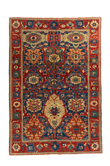 Alfombra clásica oriental en rojo y azul con diseño geométrico simétrico y guarda decorativa, vista completa