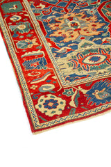 Detalle lateral de alfombra oriental con patrones geométricos en azul, rojo y beige
