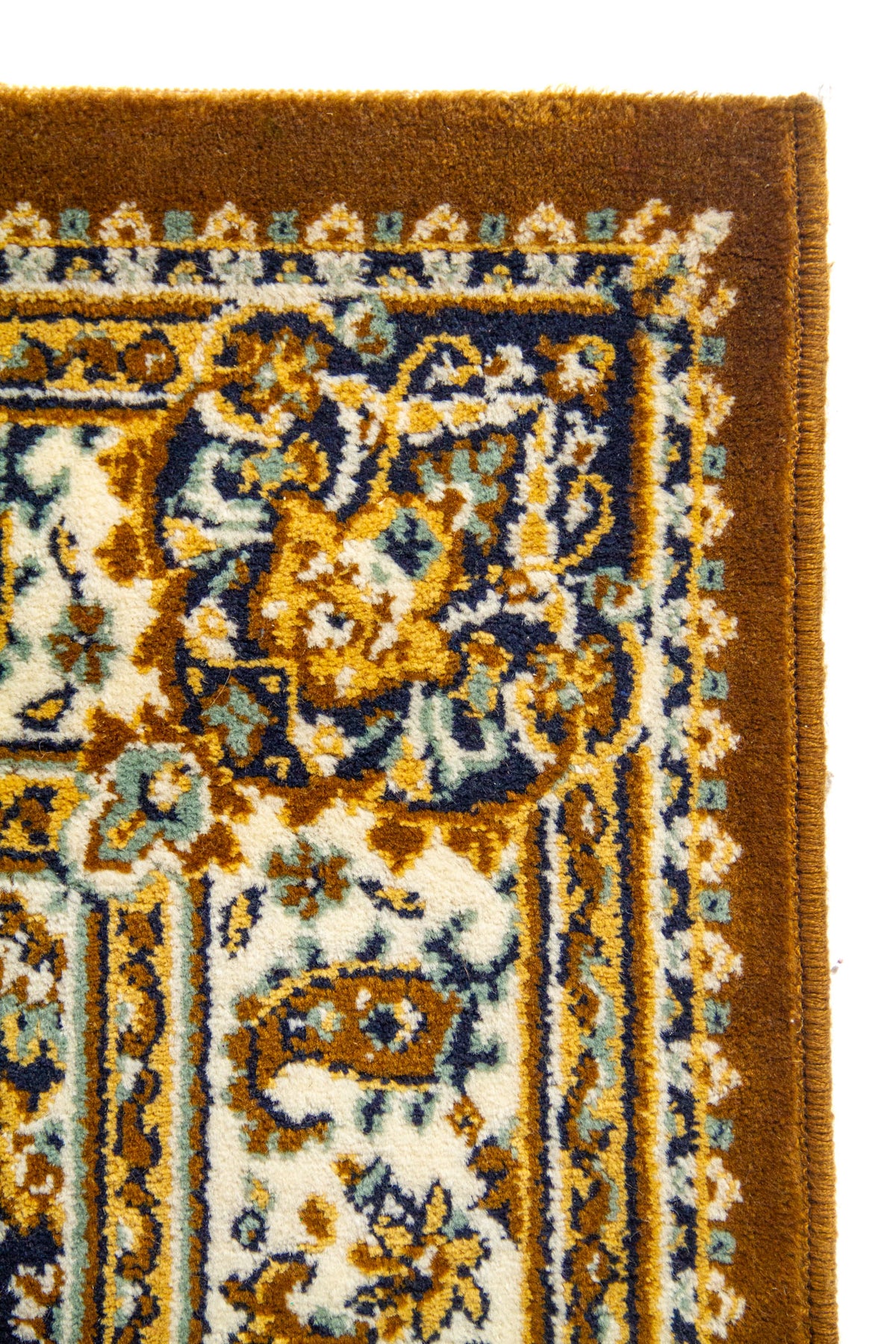 Primer plano de la esquina de una alfombra clásica con borde marrón, cenefa ornamental clara y patrones florales tradicionales.