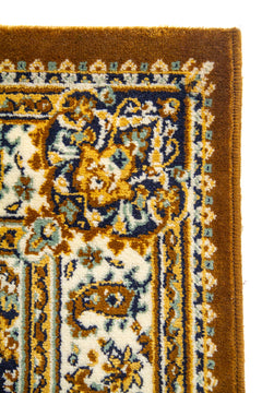 Primer plano de la esquina de una alfombra clásica con borde marrón, cenefa ornamental clara y patrones florales tradicionales.
