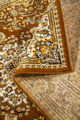Detalle de alfombra oriental parcialmente doblada que deja ver el reverso, la textura del tejido y el diseño decorativo del borde.