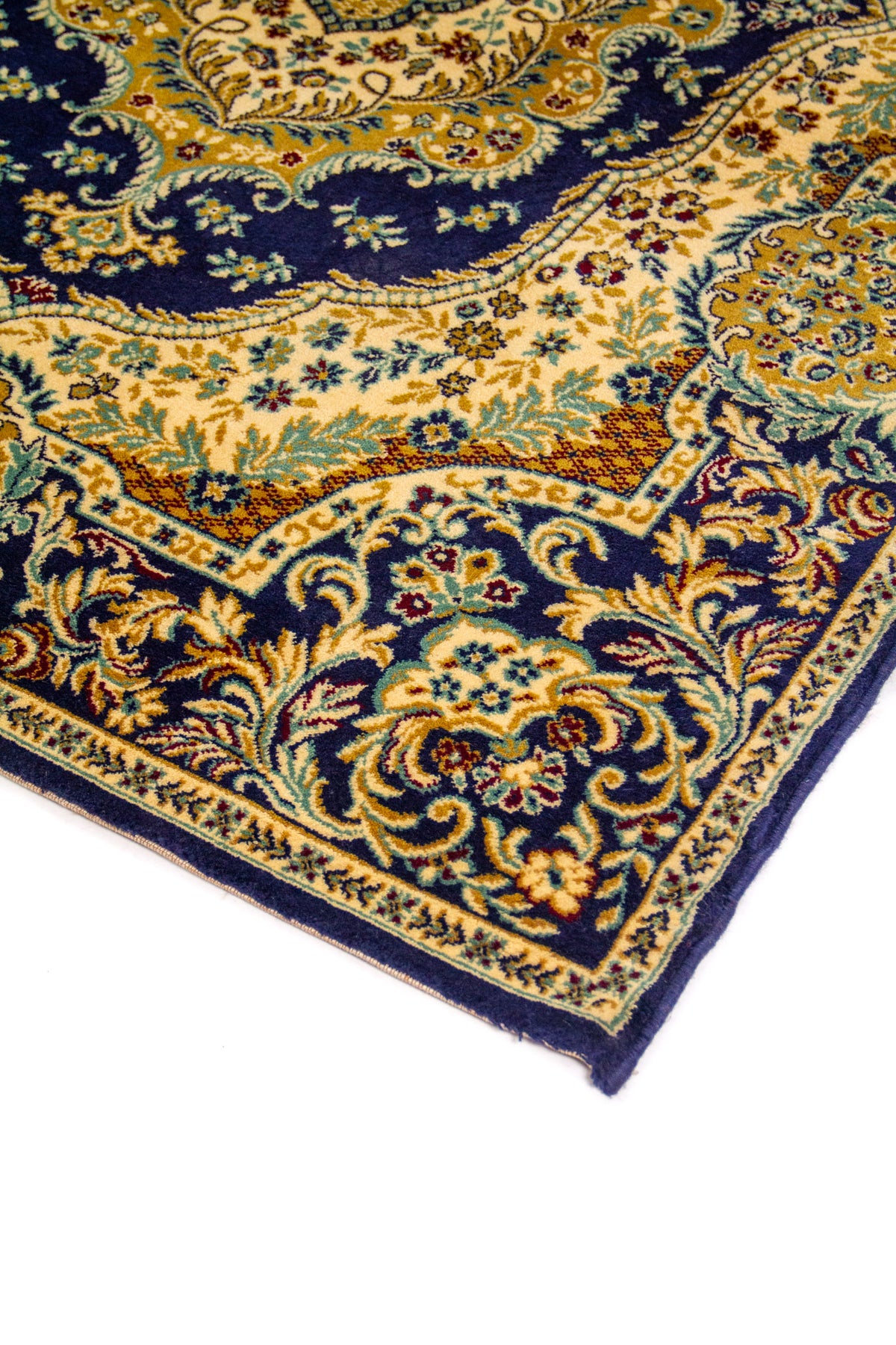 Detalle de esquina de alfombra azul marino con motivos florales y arabescos en tonos beige, dorado y celeste suave.