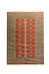 Alfombra rectangular en tonos rojo, beige, marrón y verde, con diseño geométrico repetitivo en el centro y múltiples guardas decorativas.