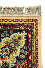 Acercamiento del borde superior de la alfombra con flecos, mostrando la riqueza de la guarda floral y los pequeños detalles decorativos en tonos cálidos y oscuros.