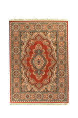 Alfombra oriental rectangular en tono rojo con medallón central blanco suave y detalles florales en azul suave, beige y negro, enmarcada por una guarda ancha con rosetones ornamentales y flecos en los extremos.