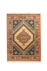 Alfombra de estilo oriental con diseño geométrico central en forma de rombo, en tonos rojo, beige, verde y rosa suave, con flecos color blanco suave.