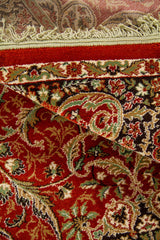 Detalle de textura y reverso de alfombra oriental anaranjado suave con diseño floral, borde decorativo y flecos en color blanco suave
