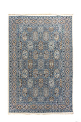 Alfombra oriental en tonos azul, beige y blanco suave  con diseño de paneles florales y guarda geométrica, vista completa