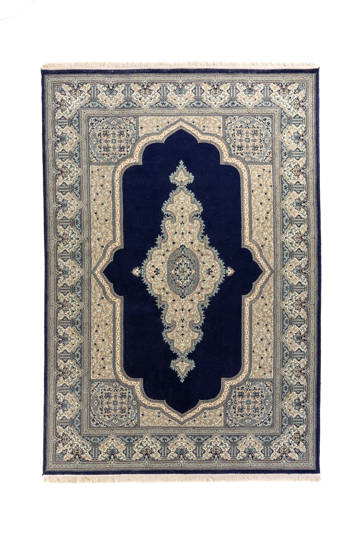 Alfombra oriental rectangular en tonos azul oscuro, blanco suave y celeste, con gran campo central azul oscuro, medallón alargado y guarda floral detallada.