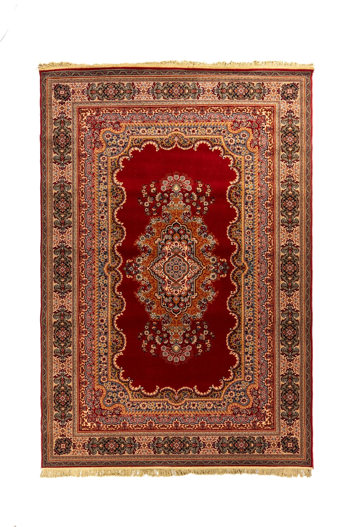 Alfombra clásica oriental en tonos rojo intenso, beige y azul con medallón central floral, guarda ornamental y flecos en los extremos.
