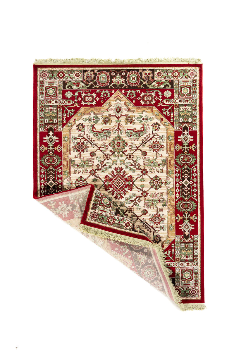 Alfombra oriental roja con una esquina doblada que muestra el reverso, la estructura del tejido, la guarda decorativa y los flecos claros.