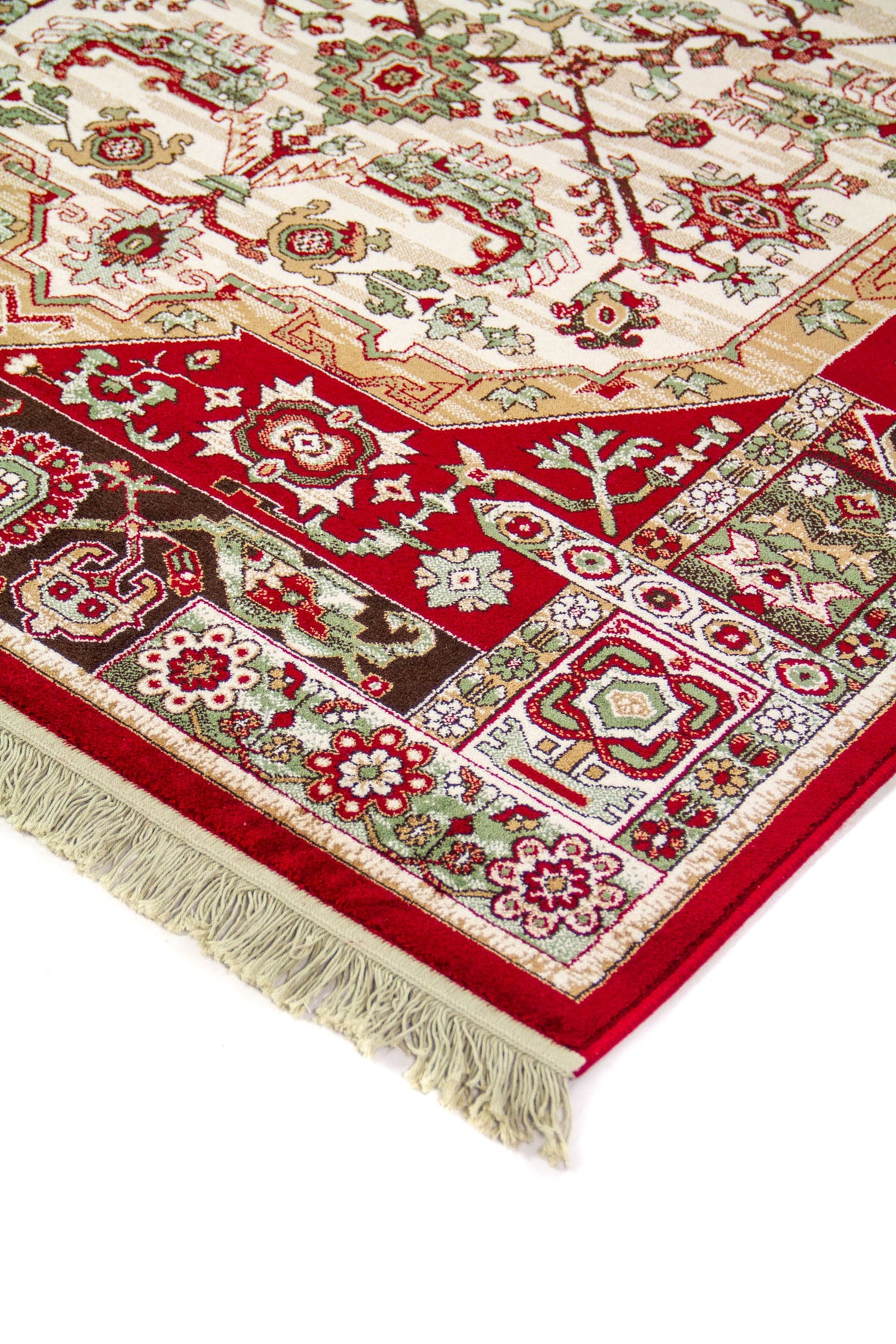 Detalle en perspectiva de alfombra clásica con borde rojo, motivos geométricos y florales en tonos blanco suave, verde y beige, y flecos en el extremo.