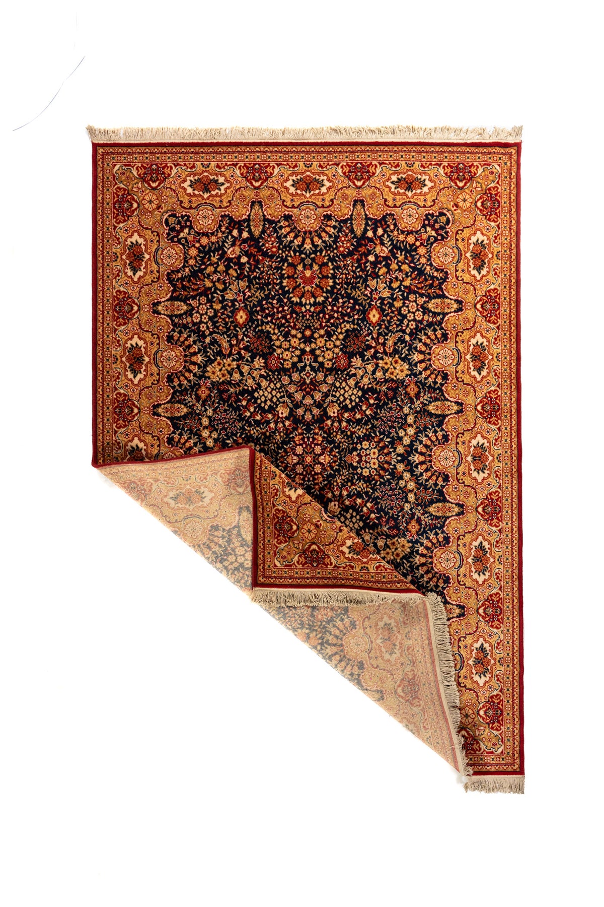 Alfombra oriental de estilo clásico con una esquina doblada que muestra el reverso, el tejido interior, la guarda decorativa y los flecos beige.