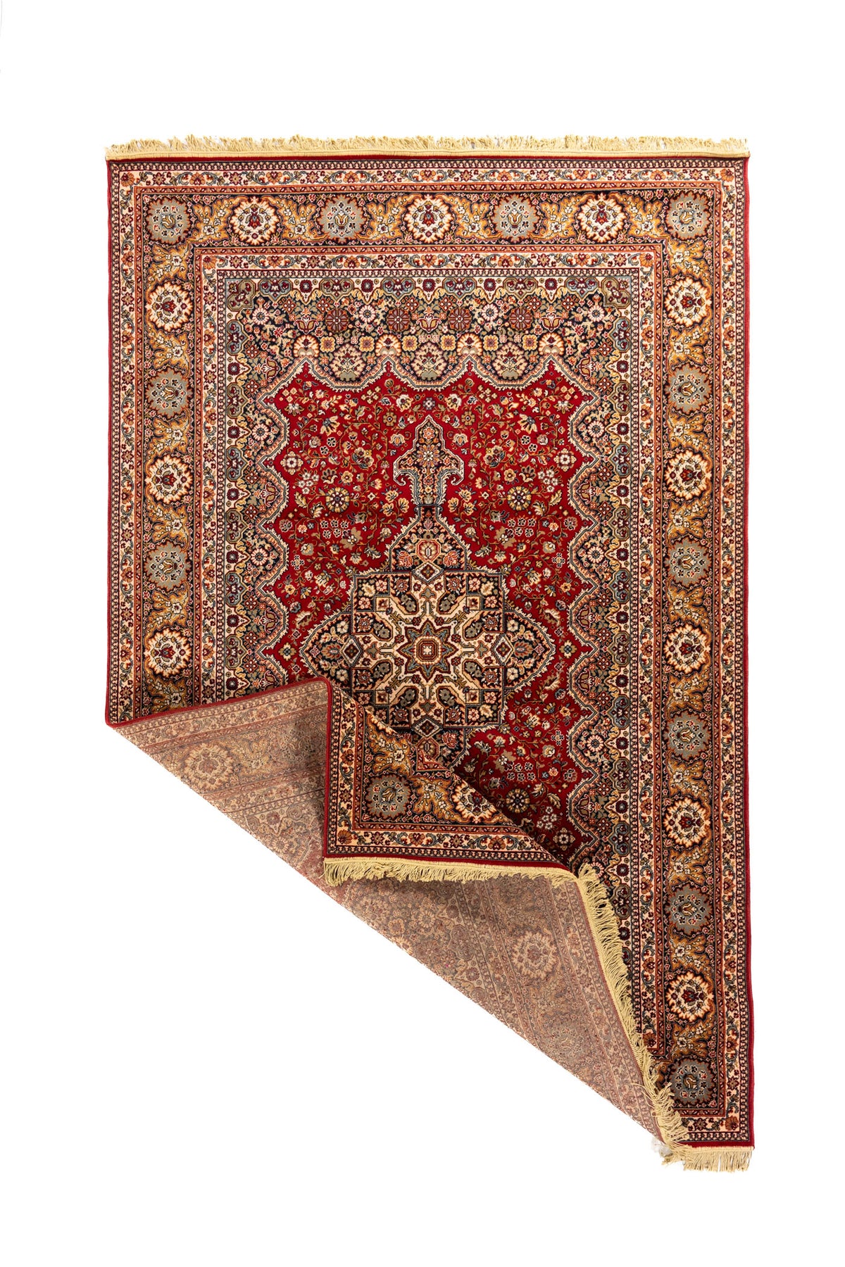 Alfombra oriental clásica con una esquina doblada que muestra el reverso, la estructura del tejido, los flecos beige y el borde decorativo.