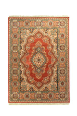 Alfombra clásica de estilo oriental en tonos rojo, beige, celeste suave y azul oscuro, con medallón central ornamental, bordes florales y flecos color blanco suave.