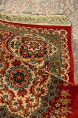 Detalle de alfombra doblada mostrando el reverso tejido, la textura del pelo y los patrones ornamentales florales del diseño.