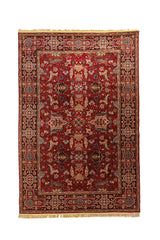 Alfombra clásica oriental en tonos rojo, azul oscuro, beige y anaranjado oscuro con diseño geométrico floral simétrico, amplia guarda ornamental y flecos en los extremos.