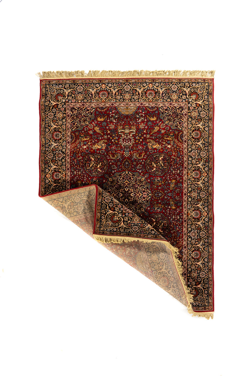 Alfombra oriental roja con una esquina levantada que muestra el reverso y el detalle de su tejido.