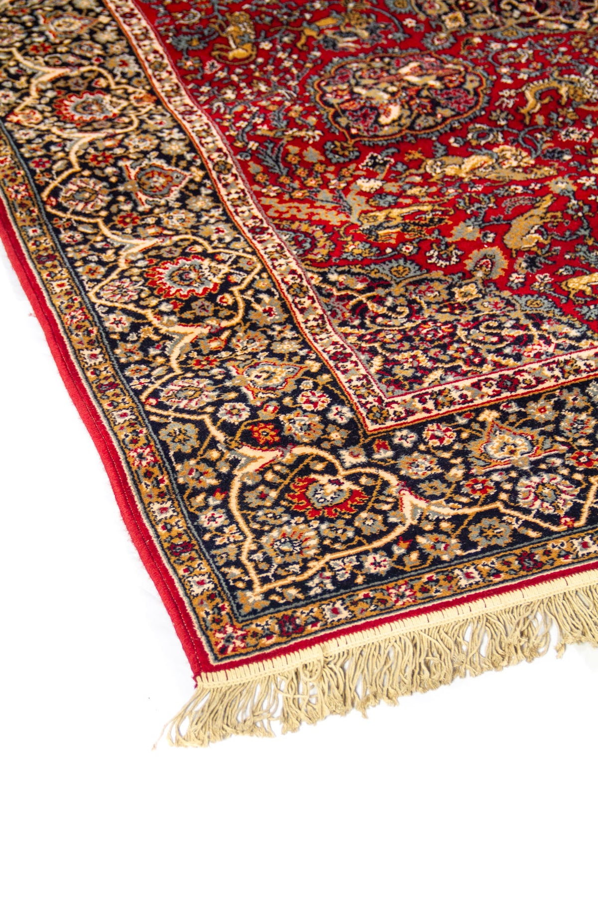 Detalle lateral de alfombra de estilo persa con fondo rojo intenso, borde azul oscuro y motivos florales