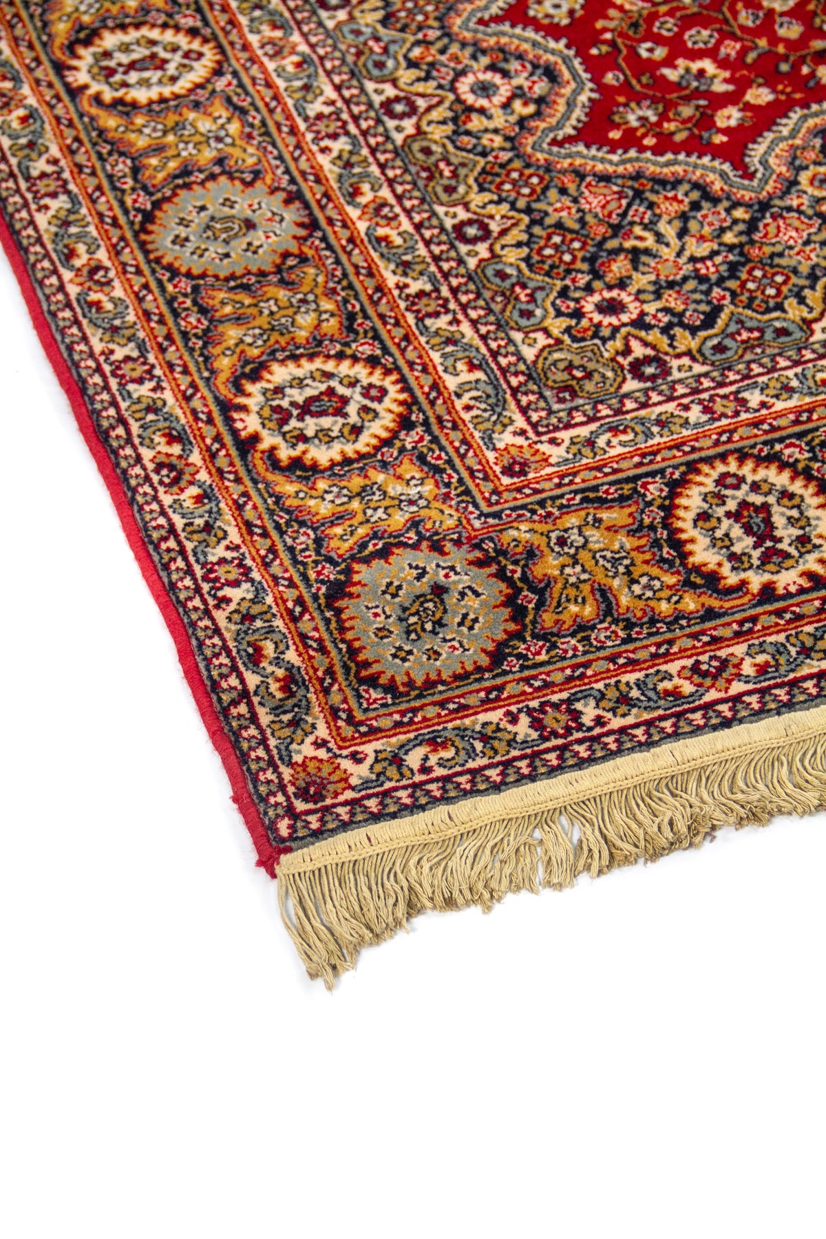 Primer plano del borde de alfombra clásica con motivos florales ornamentales y flecos en uno de los extremos