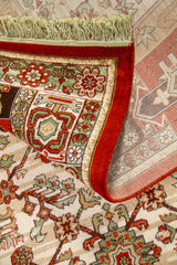 Detalle de alfombra doblada mostrando la textura, el reverso del tejido y el diseño geométrico del borde en tonos rojo y verde