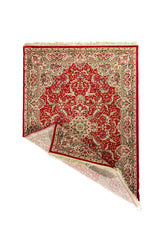 Alfombra oriental roja con diseño floral ornamentado y esquina levantada que muestra su flexibilidad y terminación con flecos.