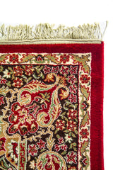 Detalle superior de alfombra oriental roja con flecos blanco suave, borde ancho rojo y guarda floral de inspiración clásica.