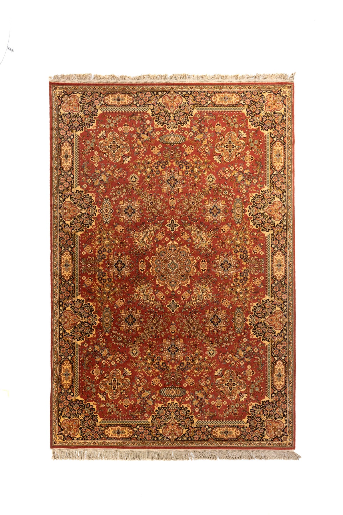Alfombra clásica oriental en tonos anaranjado oscuro, beige, azul oscuro y verde suave con diseño floral simétrico, guarda ornamental ancha y flecos en los extremos.