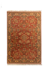 Alfombra clásica oriental en tonos anaranjado oscuro, beige, azul oscuro y verde suave con diseño floral simétrico, guarda ornamental ancha y flecos en los extremos.