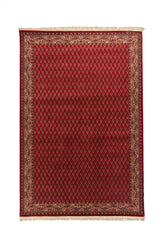 Alfombra oriental rectangular de fondo rojo intenso con guarda decorativa en tonos blanco suave, azul y rojo, y flecos claros en los extremos.