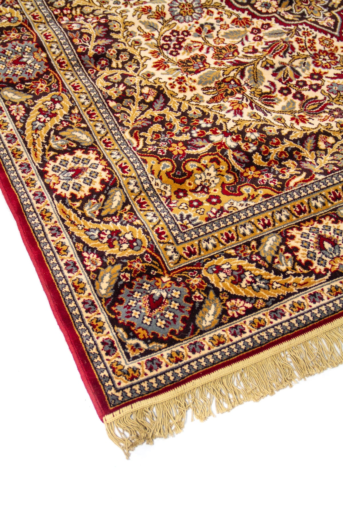 Primer plano de alfombra clásica con motivos florales ornamentales, medallón central y guarda decorativa en tonos rojo oscuro, azul y beige