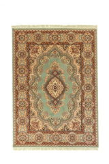 Alfombra oriental rectangular en tono verde con medallón central beige y guarda ornamental en tonos beige, rojo y azul