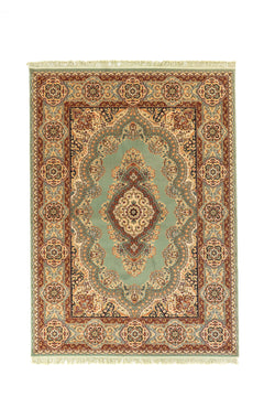Alfombra oriental rectangular en tono verde con medallón central beige y guarda ornamental en tonos beige, rojo y azul