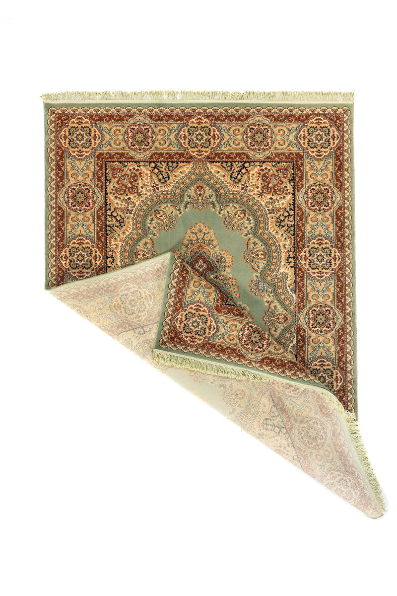 Alfombra clásica rectangular con una esquina doblada que muestra el reverso del tejido, los flecos y el diseño decorativo del borde