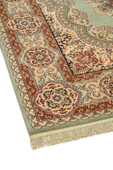 Primer plano del borde de alfombra oriental con fondo verde suave, guarda decorativa y diseño floral tradicional