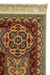 Detalle de esquina superior de alfombra clásica con flecos beige y borde decorativo en tonos verde, rojo, beige y azul oscuro
