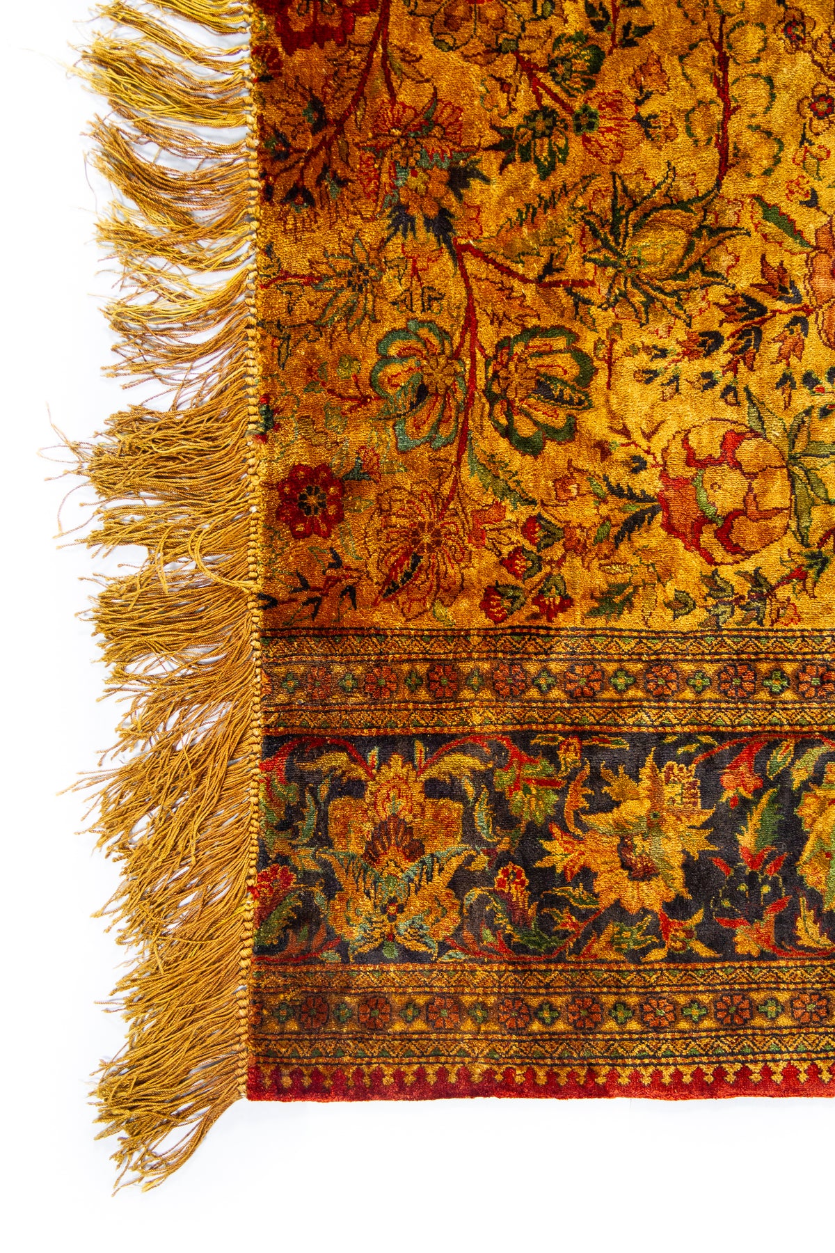 Detalle de flecos y diseño floral de alfombra Ispahan Seda Fragmento en tonos ocre y verde