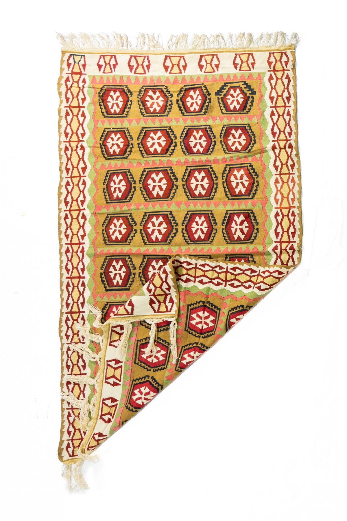 Alfombra de estilo geométrico con esquina doblada, en colores beige, dorado, rojo, rosa y verde, que muestra su flexibilidad y tejido.