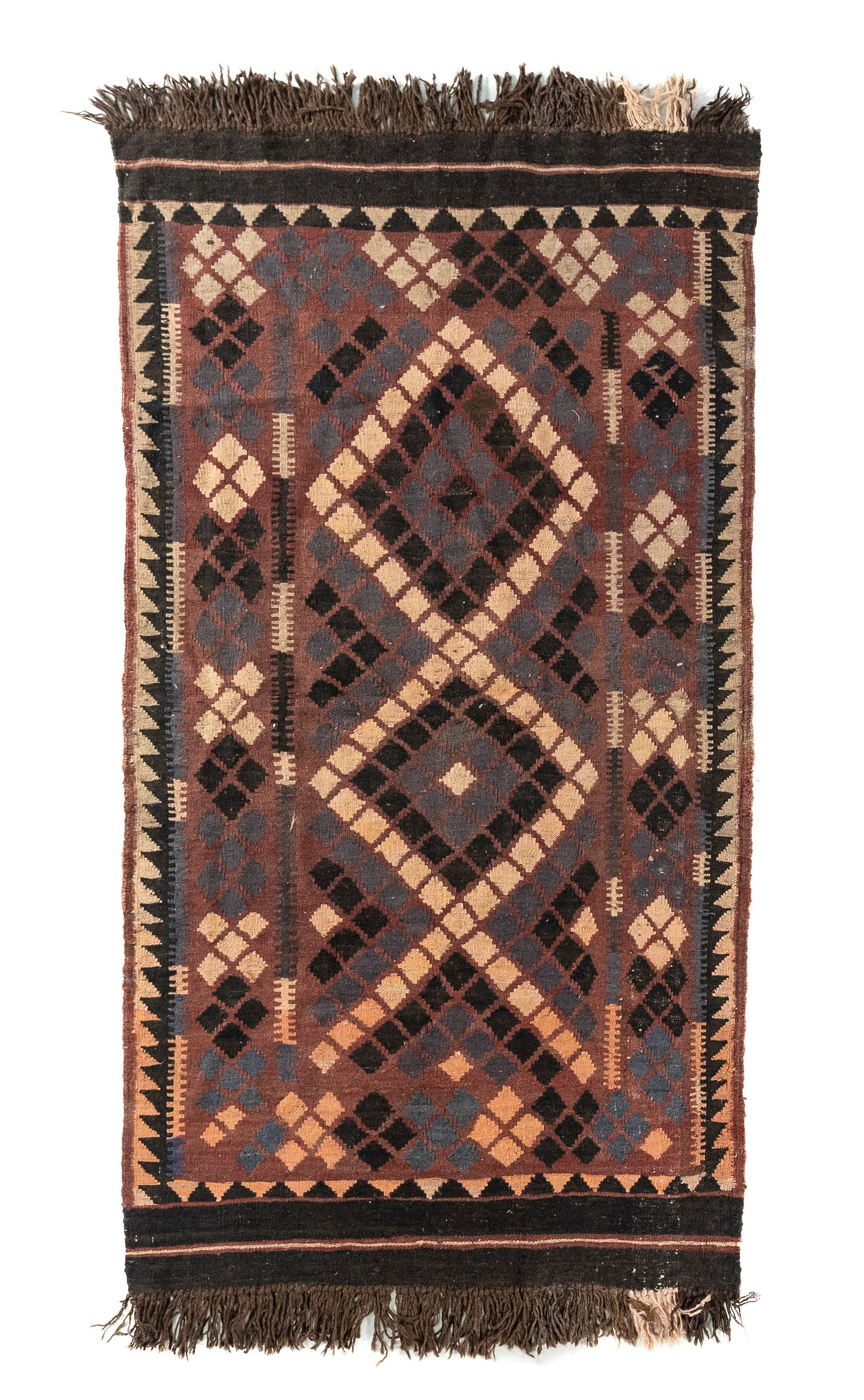Alfombra rectangular artesanal en tonos marrón, negro, beige y gris, con diseño geométrico tribal de rombos entrelazados y flecos en ambos extremos.