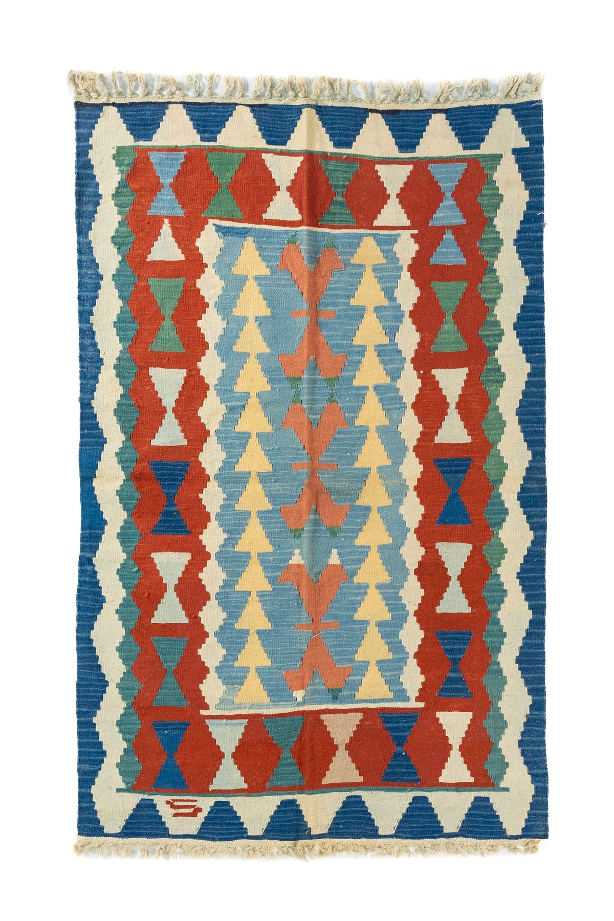 Alfombra de estilo kilim con diseño geométrico en tonos azul, rojo, celeste, beige y verde suave sobre fondo claro.