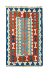 Alfombra de estilo kilim con diseño geométrico en tonos azul, rojo, celeste, beige y verde suave sobre fondo claro.