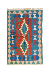 Alfombra estilo kilim con diseño geométrico en tonos rojo, azul, verde y beige.